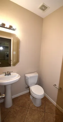 a bathroom with a toilet a sink and mirror