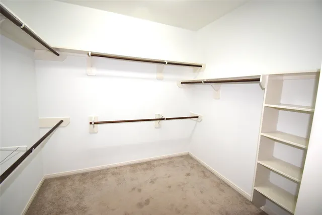 a view of walk in closet with empty racks