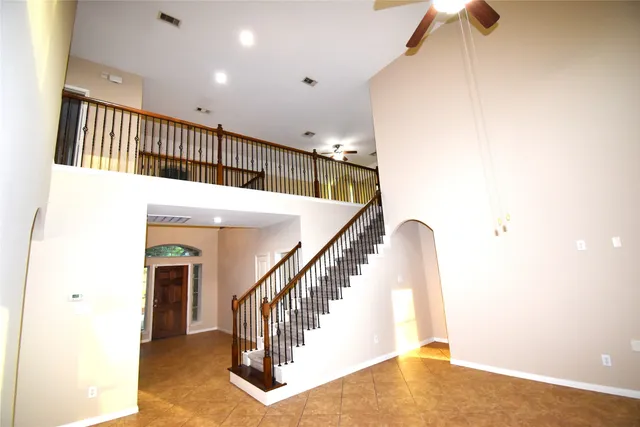 a view of staircase with railing and white walls