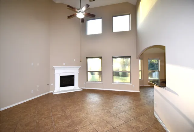 an empty room with windows and fireplace