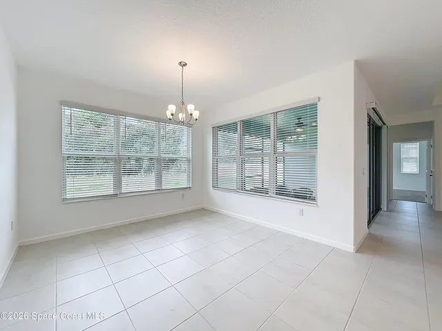 a view of an empty room with glass door and windows