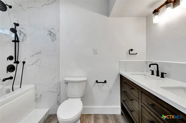 a bathroom with a sink a toilet and shower