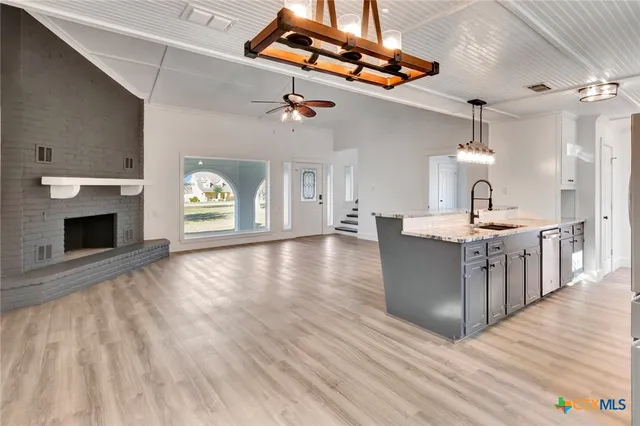 a large kitchen with cabinets wooden floor and a fireplace