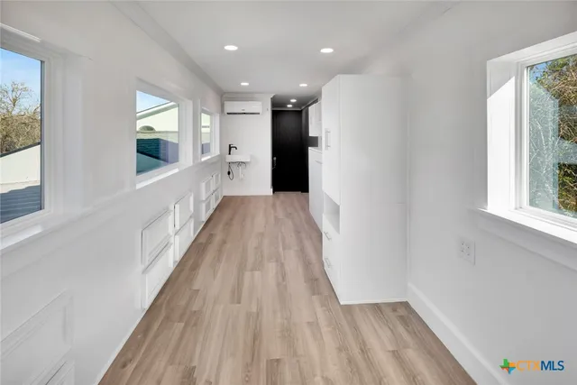 a view of a hallway with wooden floor and staircase