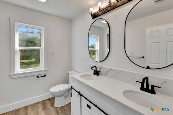 a bathroom with a sink a toilet and a mirror