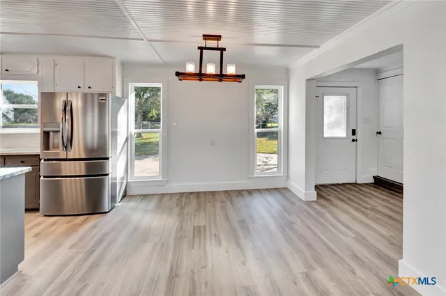 a view of a kitchen with wooden floor and a refrigerator