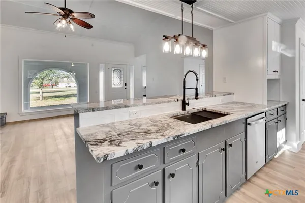 a view of a kitchen with a sink and chandelier