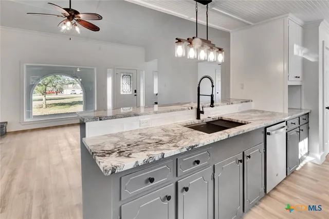 a view of a kitchen with a sink and chandelier