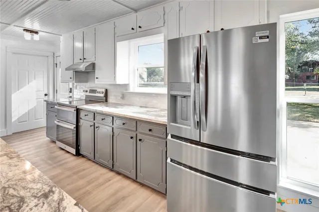 a kitchen with stainless steel appliances a refrigerator sink and cabinets