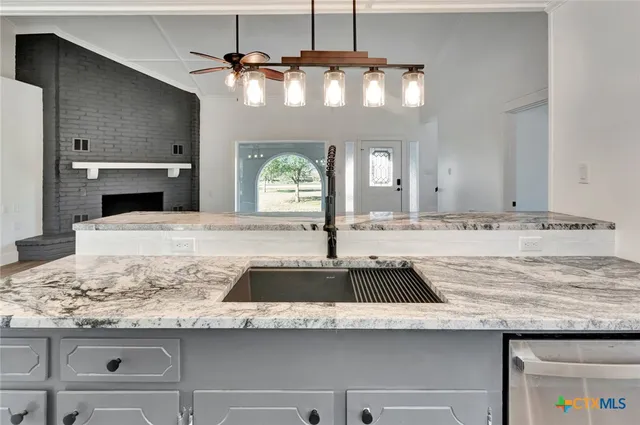 a view of kitchen with granite countertop a sink and a stove