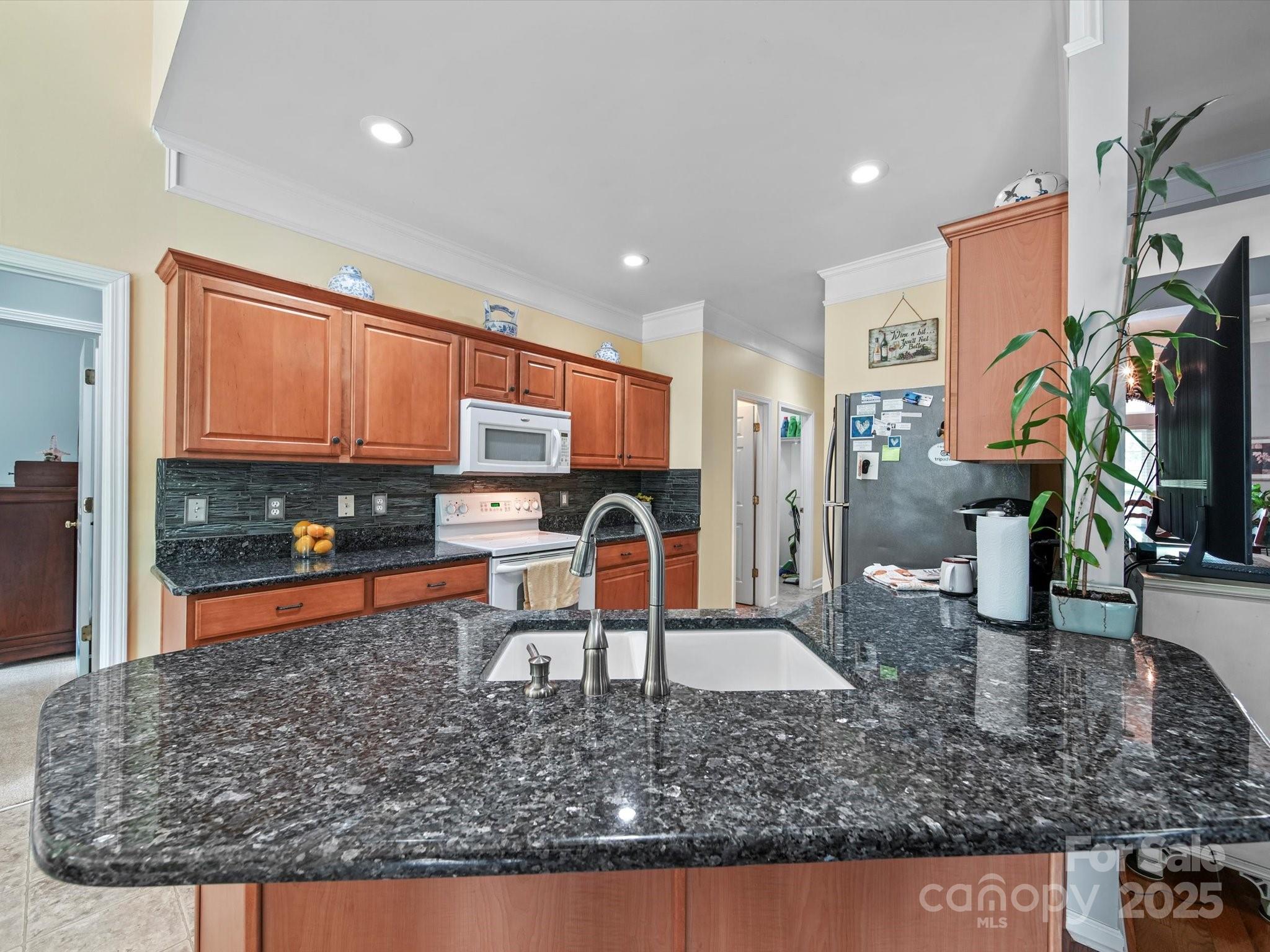 11761 Crossroads Place Concord, NC 28025 - Photo 12 of 32 a kitchen with stainless steel appliances granite countertop a sink a stove and a wooden floors
