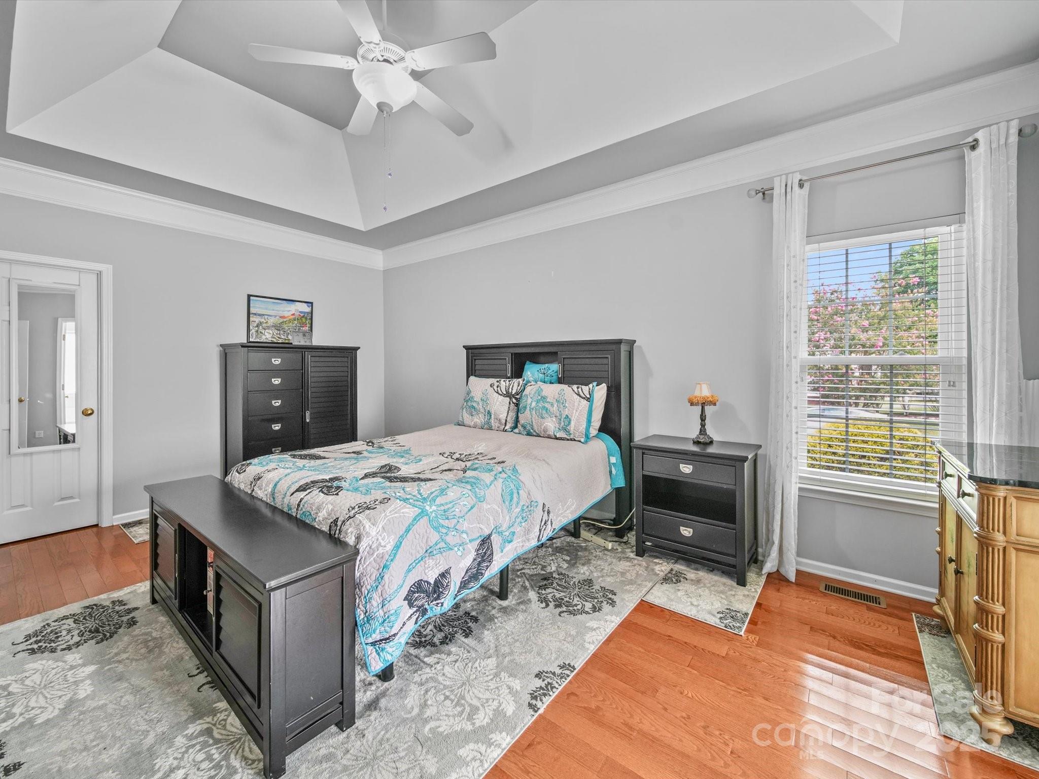 11761 Crossroads Place Concord, NC 28025 - Photo 21 of 32 a bedroom with a bed and a chandelier