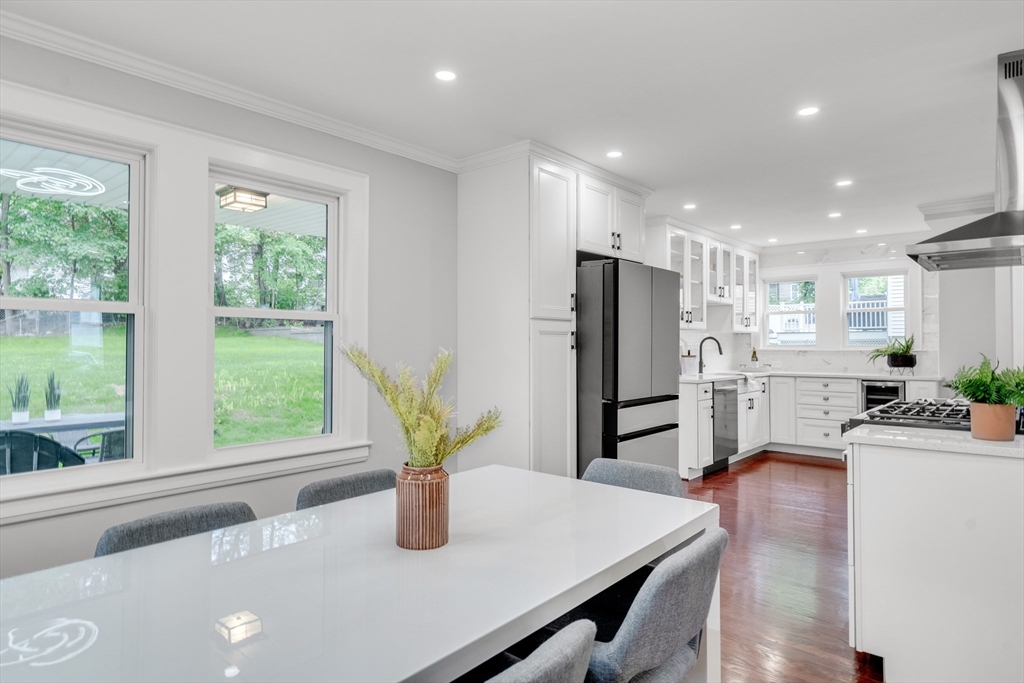 56 Pine Hill Road Dedham, MA 02026 - Photo 13 of 32 a kitchen with stainless steel appliances granite countertop sink refrigerator dining table and chairs