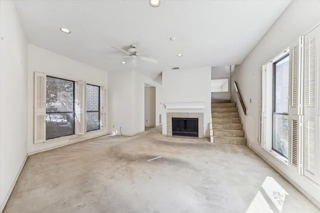 an empty room with windows and fireplace
