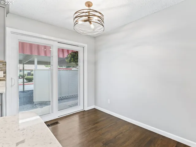 an empty room with wooden floor and window