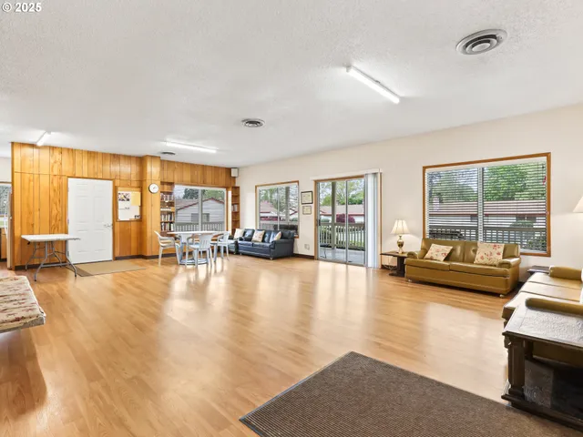 a view of a livingroom with furniture wooden floor and a floor to ceiling window
