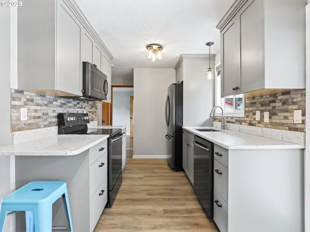a kitchen with a refrigerator sink and white cabinets