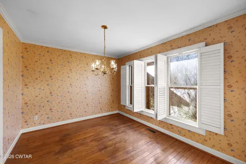 a view of a room with wooden floor and windows