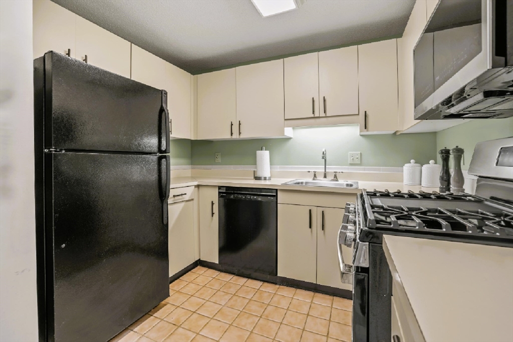 4234 North Main Street, Unit 208 Fall River, MA 02720 - Photo 5 of 27 a kitchen with a refrigerator sink and cabinets