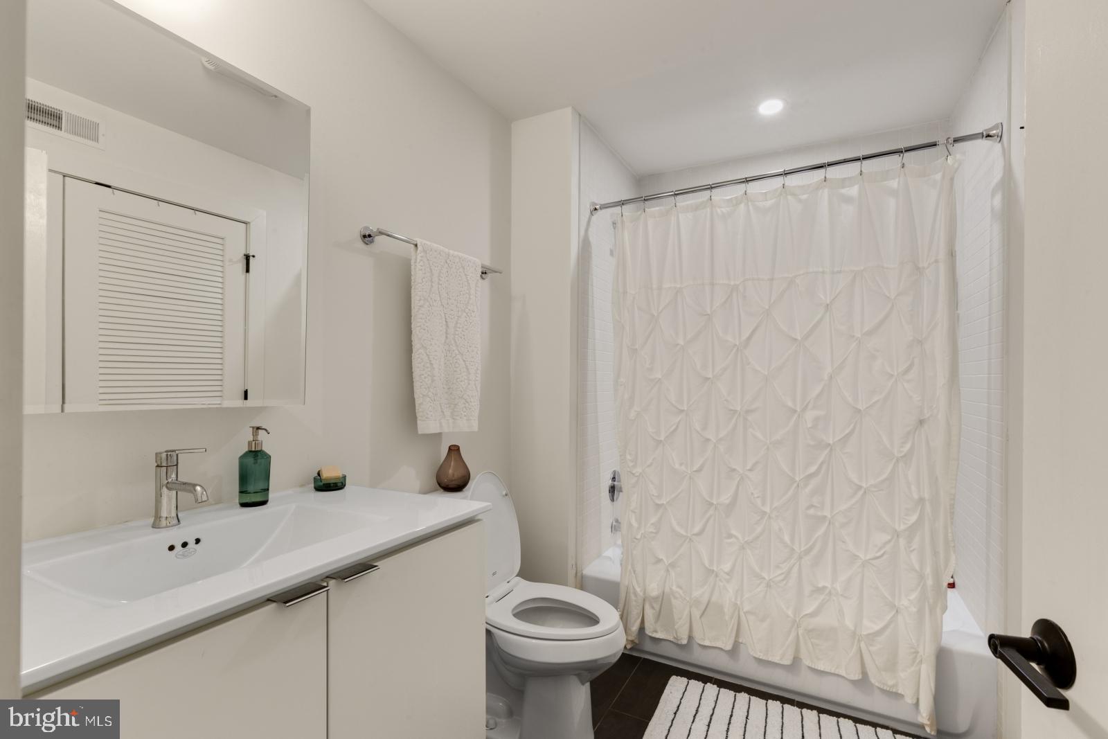 630 Federal Street, Unit 304 Philadelphia, PA 19147 - Photo 16 of 26 a bathroom with a sink a toilet and shower curtain