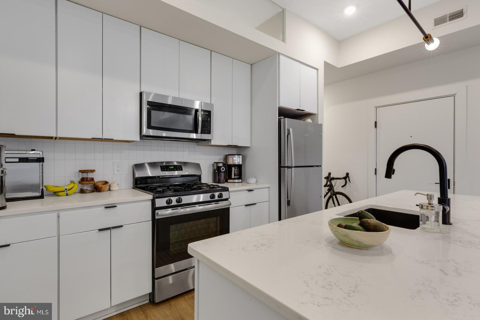 630 Federal Street, Unit 304 Philadelphia, PA 19147 - Photo 3 of 26 a kitchen with stainless steel appliances granite countertop a sink a stove and refrigerator
