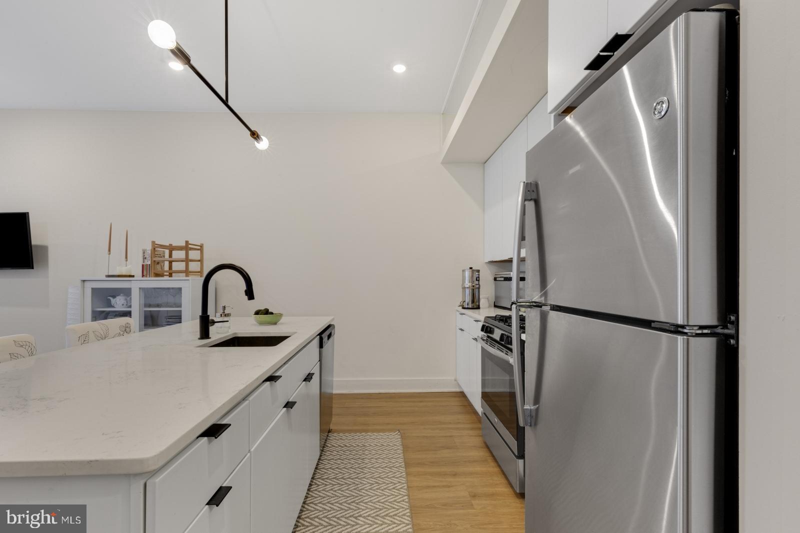 630 Federal Street, Unit 304 Philadelphia, PA 19147 - Photo 4 of 26 a kitchen with stainless steel appliances a refrigerator a sink a stove and white cabinets