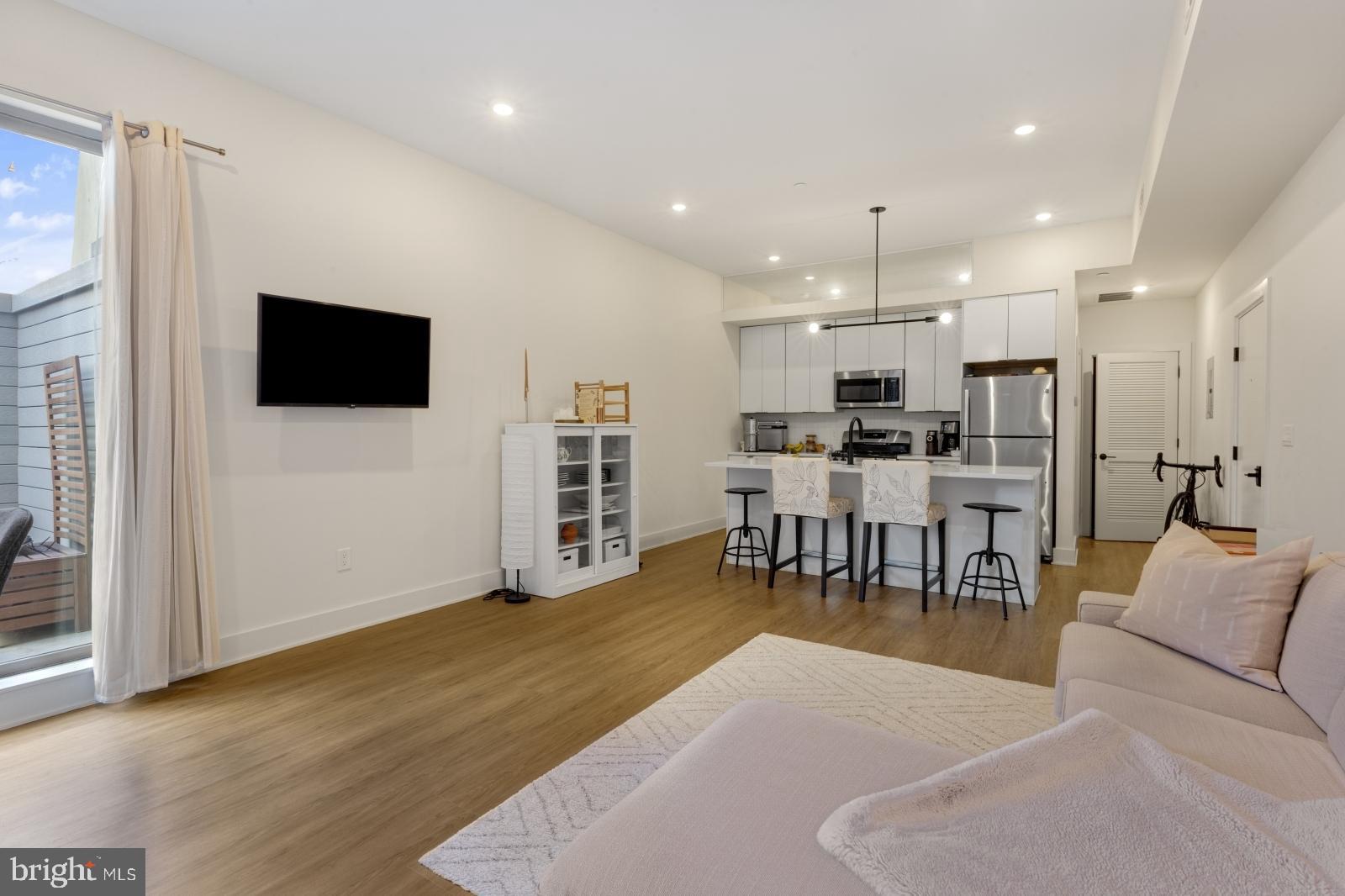 630 Federal Street, Unit 304 Philadelphia, PA 19147 - Photo 7 of 26 a living room with lots of furniture and kitchen view