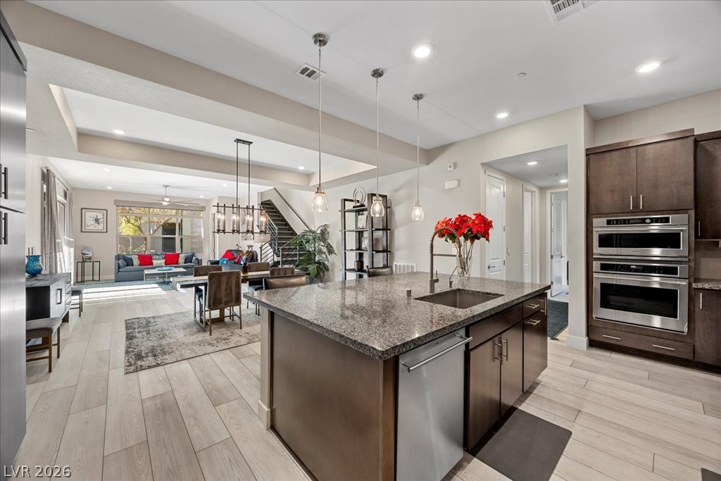 4262 Swift Street Las Vegas, NV 89135 - Photo 75 of 75 Kitchen with dark stone countertops, dark brown cabinetry, open floor plan, appliances with stainless steel finishes, and modern cabinets