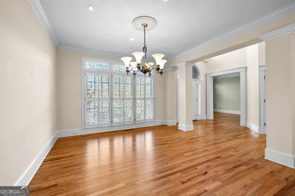 a view of an empty room with wooden floor fireplace and a window