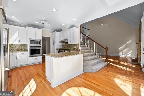 a living room with furniture a large window and a flat screen tv
