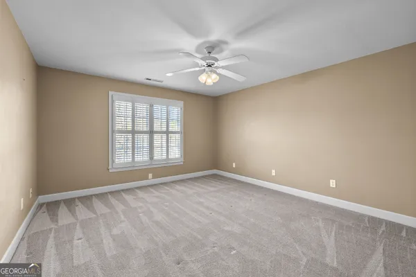an empty room with windows and fireplace