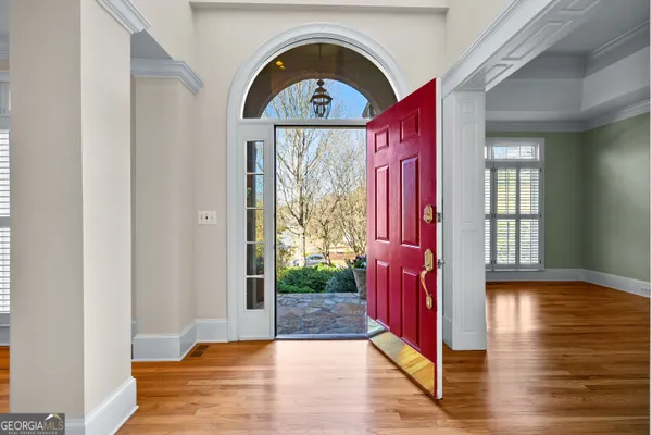 a view of a room with wooden floor and chandelier