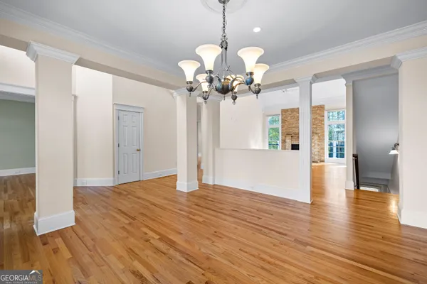 a dining room with furniture a large window and wooden floor