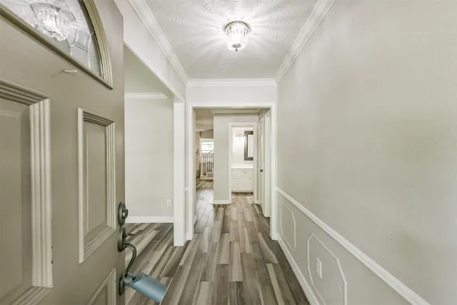 a view of a hallway with wooden floor and staircase
