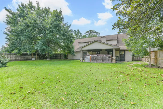 a view of a house with backyard and a tree