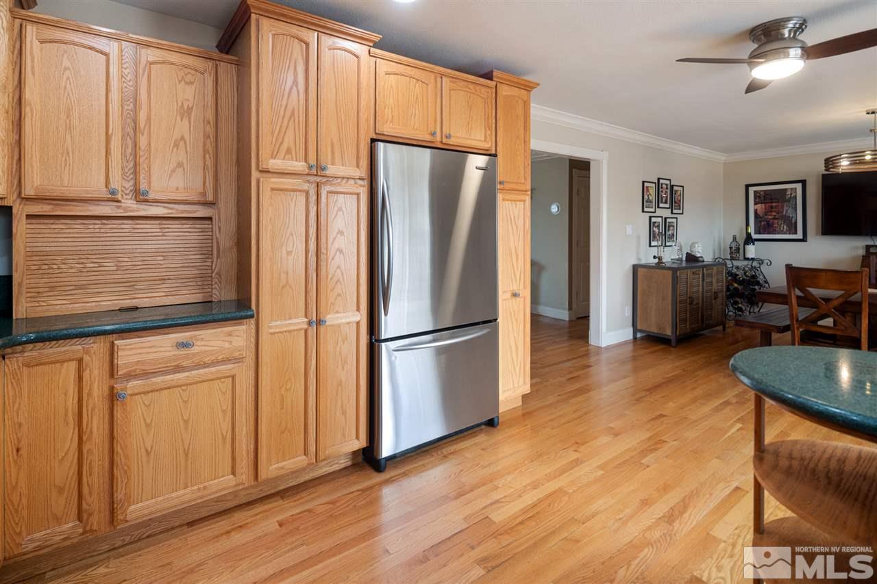 2575 Valmar Place Reno, NV 89503 - Photo 13 of 34 a kitchen with stainless steel appliances granite countertop a refrigerator a microwave oven cabinets and wooden floor