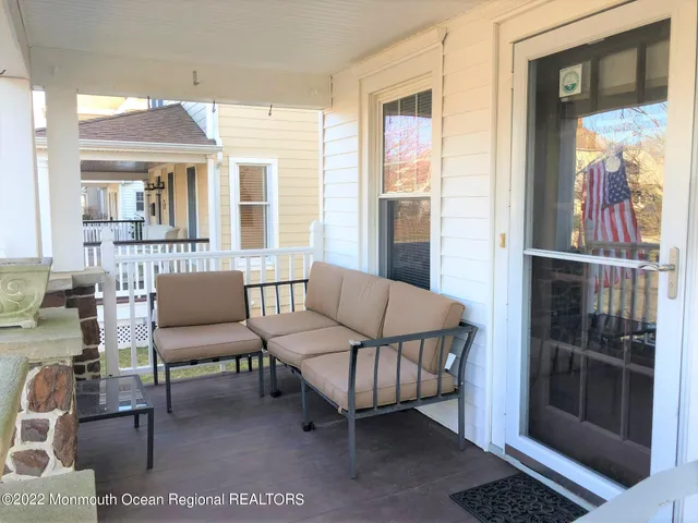 a living room with furniture a flat screen tv and a floor to ceiling window