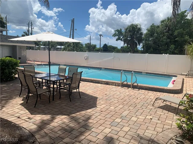 a view of a patio with a table and chairs under an umbrella