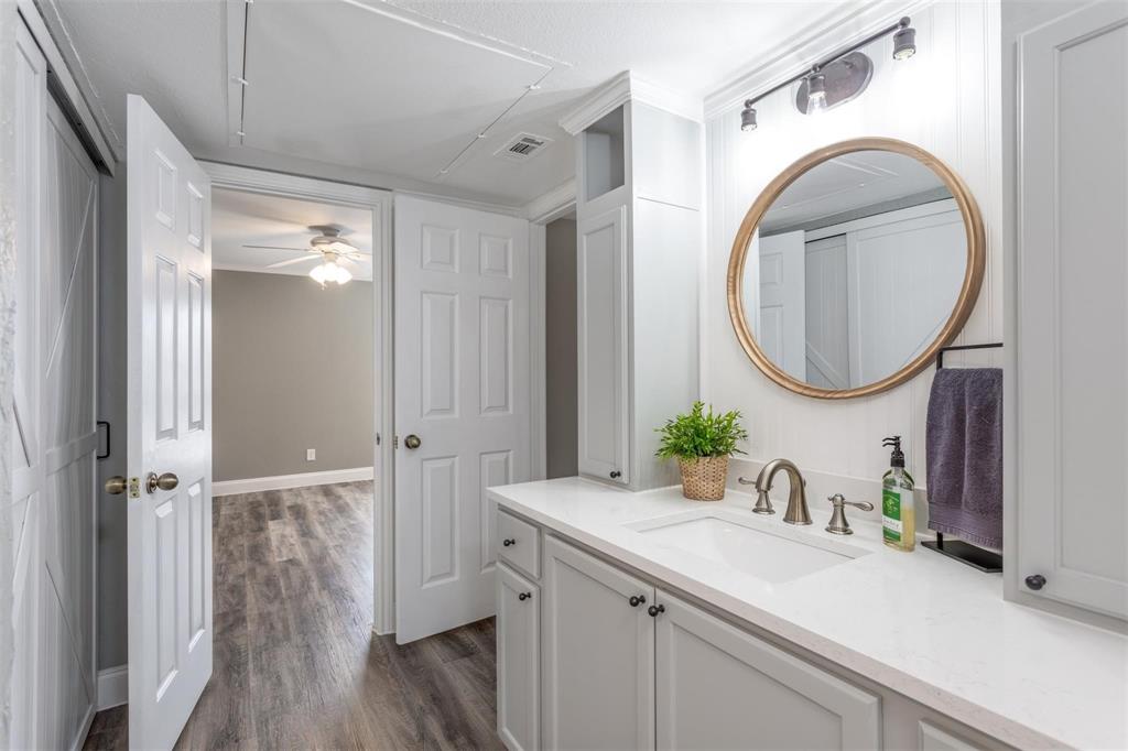16301 Ledgemont Lane, Unit 283 Addison, TX 75001 - Photo 13 of 16 Beautiful updated bathroom with single sink, ample countertop space, storage and gold trimmed round mirror. Ensuite to bedroom and living area.