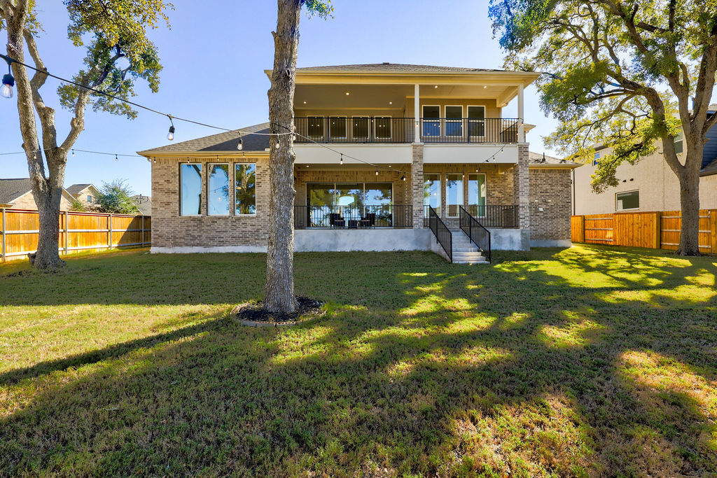 351 Pigeon River Road Kyle, TX 78640 - Photo 25 of 40 Rear view of house with a balcony, a patio area, brick siding, and a fenced backyard