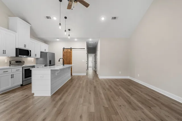 a large white kitchen with a white stove top oven and refrigerator