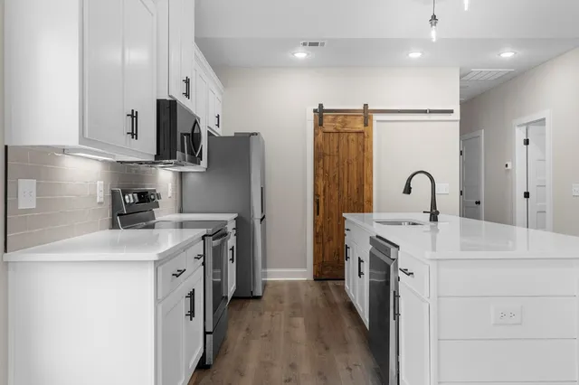 a kitchen with stainless steel appliances a sink stove and refrigerator