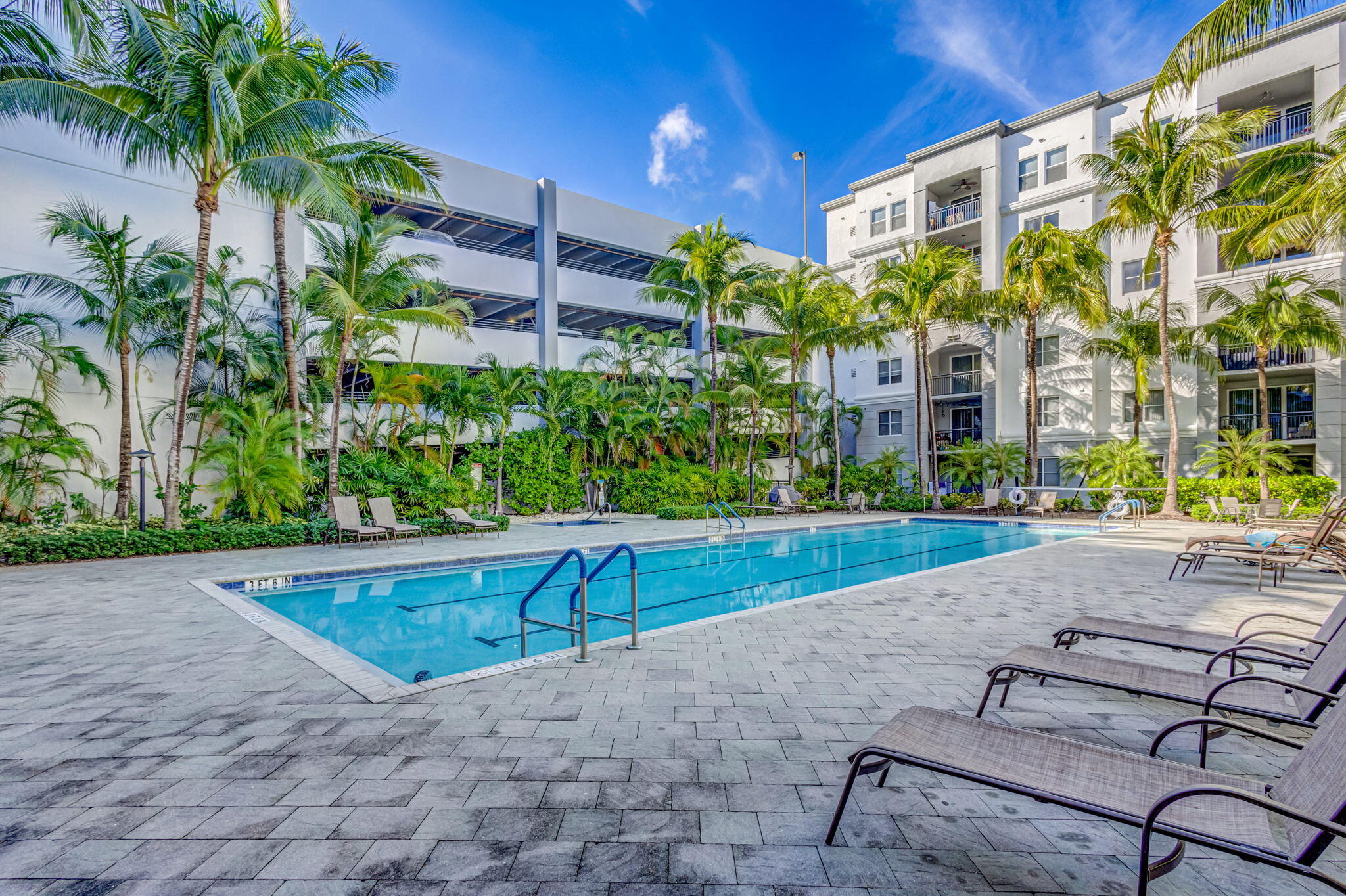 1660 Renaissance Commons Boulevard, Unit 2627 Boynton Beach, FL 33426 - Photo 22 of 32 a view of a patio with a table and chairs under an umbrella