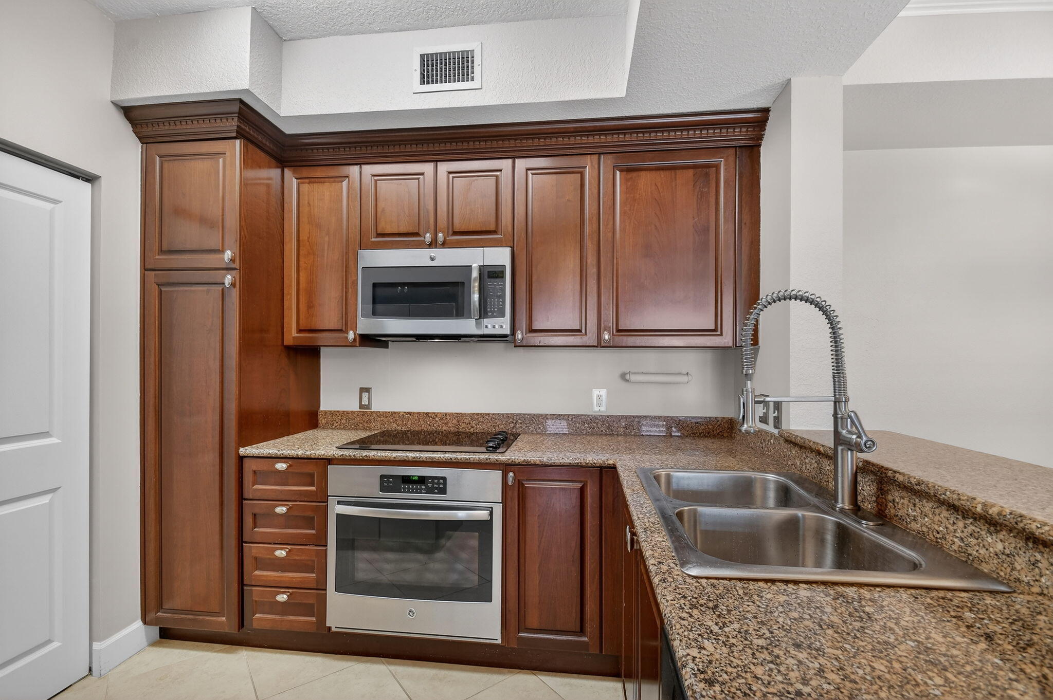 1660 Renaissance Commons Boulevard, Unit 2627 Boynton Beach, FL 33426 - Photo 3 of 32 a kitchen with granite countertop a sink and steel appliances
