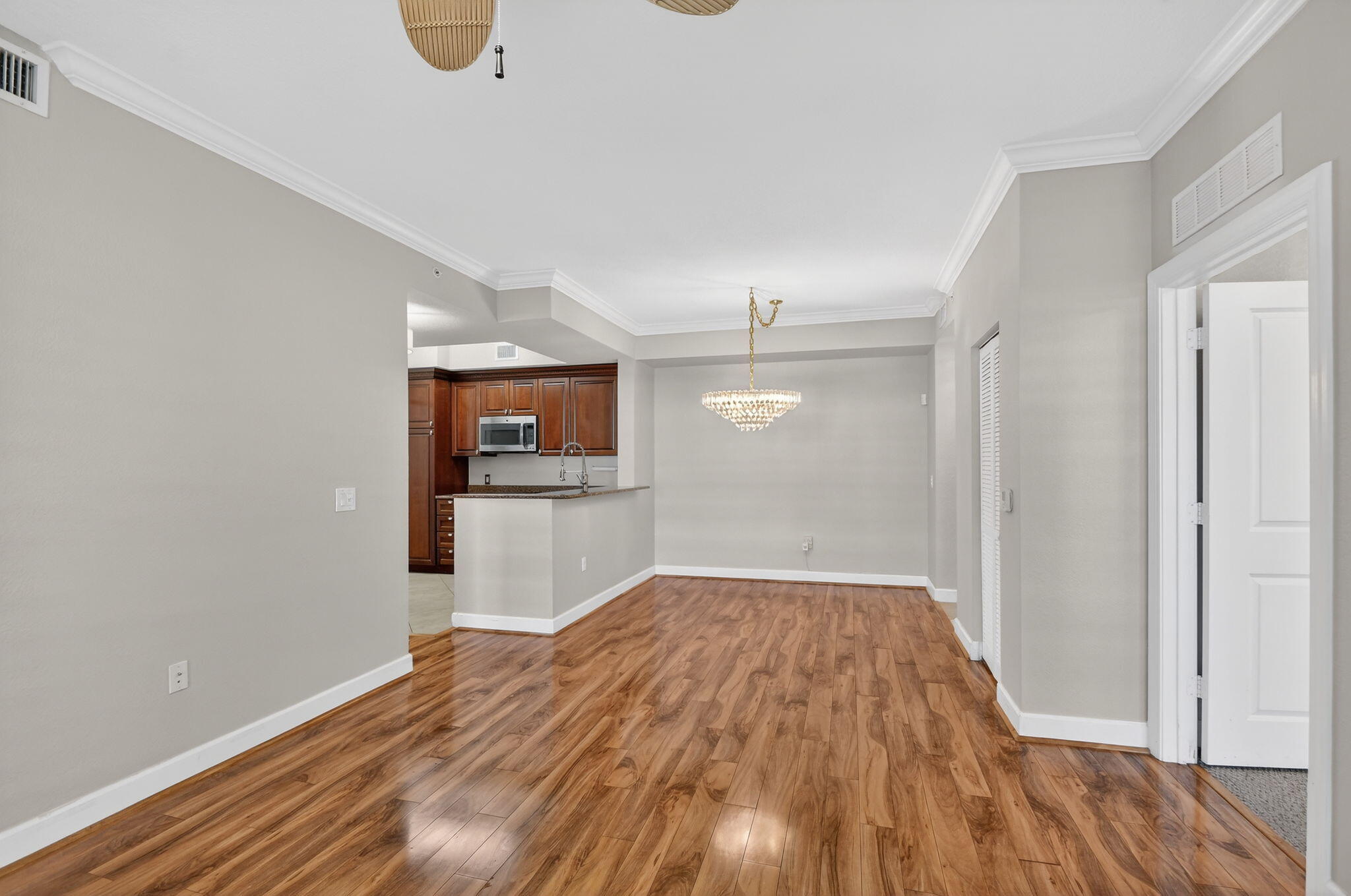 1660 Renaissance Commons Boulevard, Unit 2627 Boynton Beach, FL 33426 - Photo 32 of 32 a view of a big room with wooden floor and a kitchen