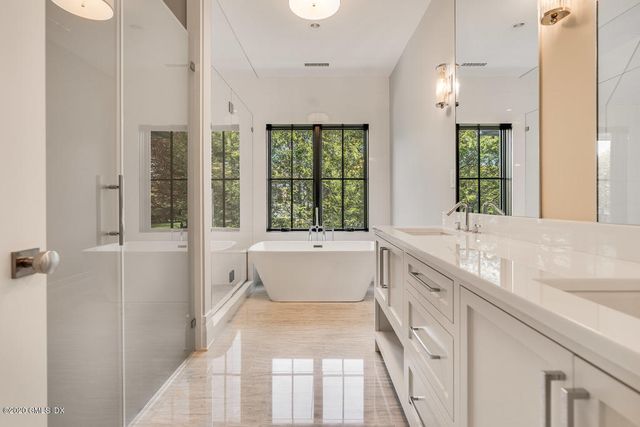 a bathroom with a granite countertop tub sink and mirror