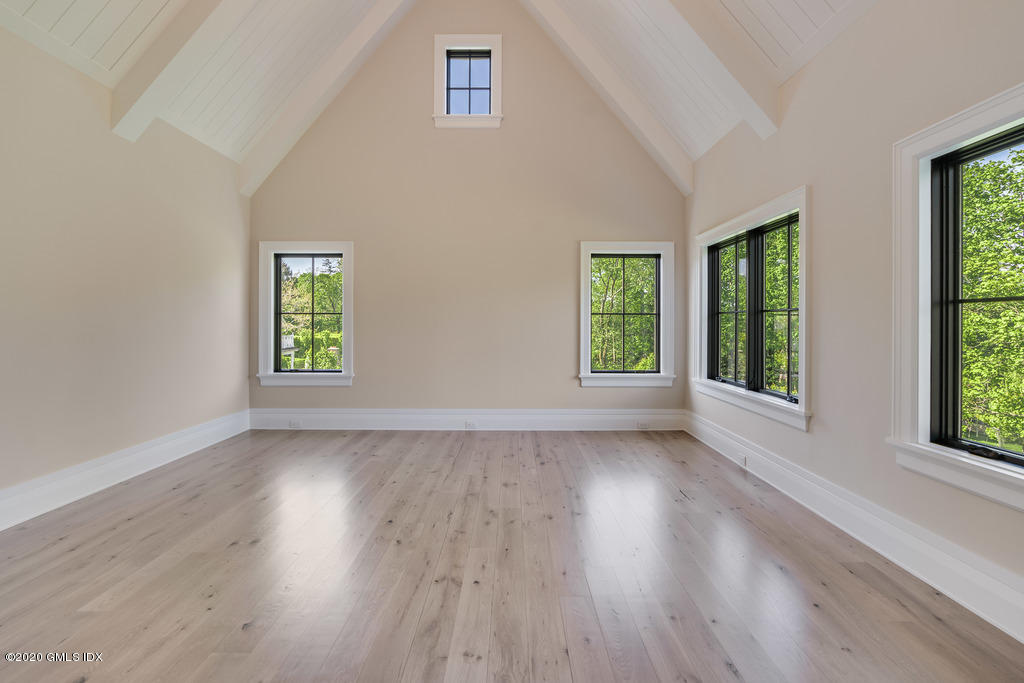 180 Stanwich Road Greenwich, CT 06830 - Photo 10 of 19 an empty room with wooden floor and windows