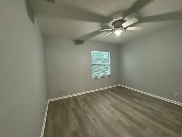 an empty room with a window and wooden floor