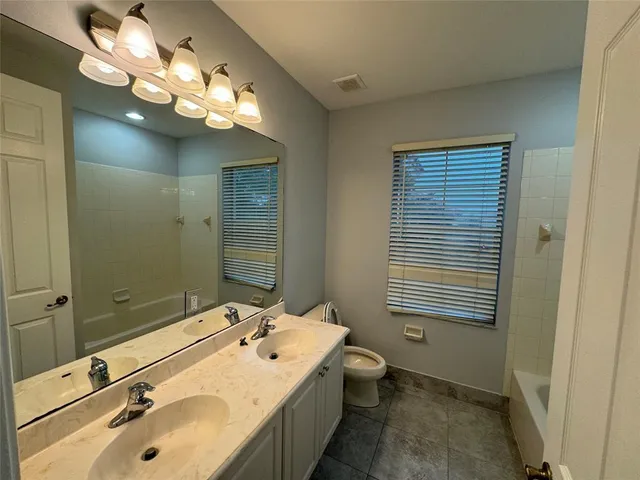 a bathroom with a tub a sink and mirror