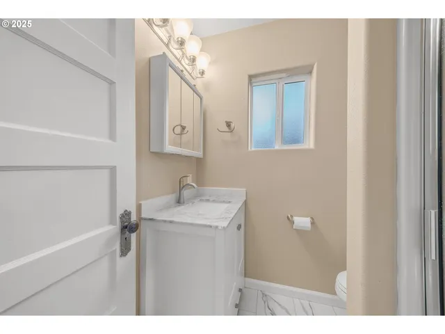a bathroom with a sink mirror and a toilet